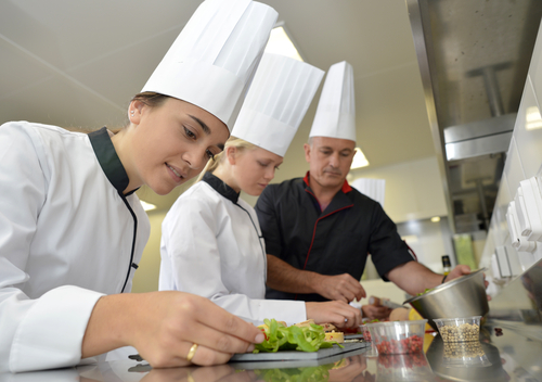Pastry chef decorating a cake in a catering kitchen – catering job placements