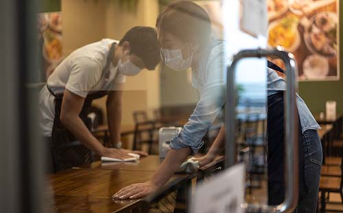 Barista making coffee at a bustling café – hospitality workforce solutions