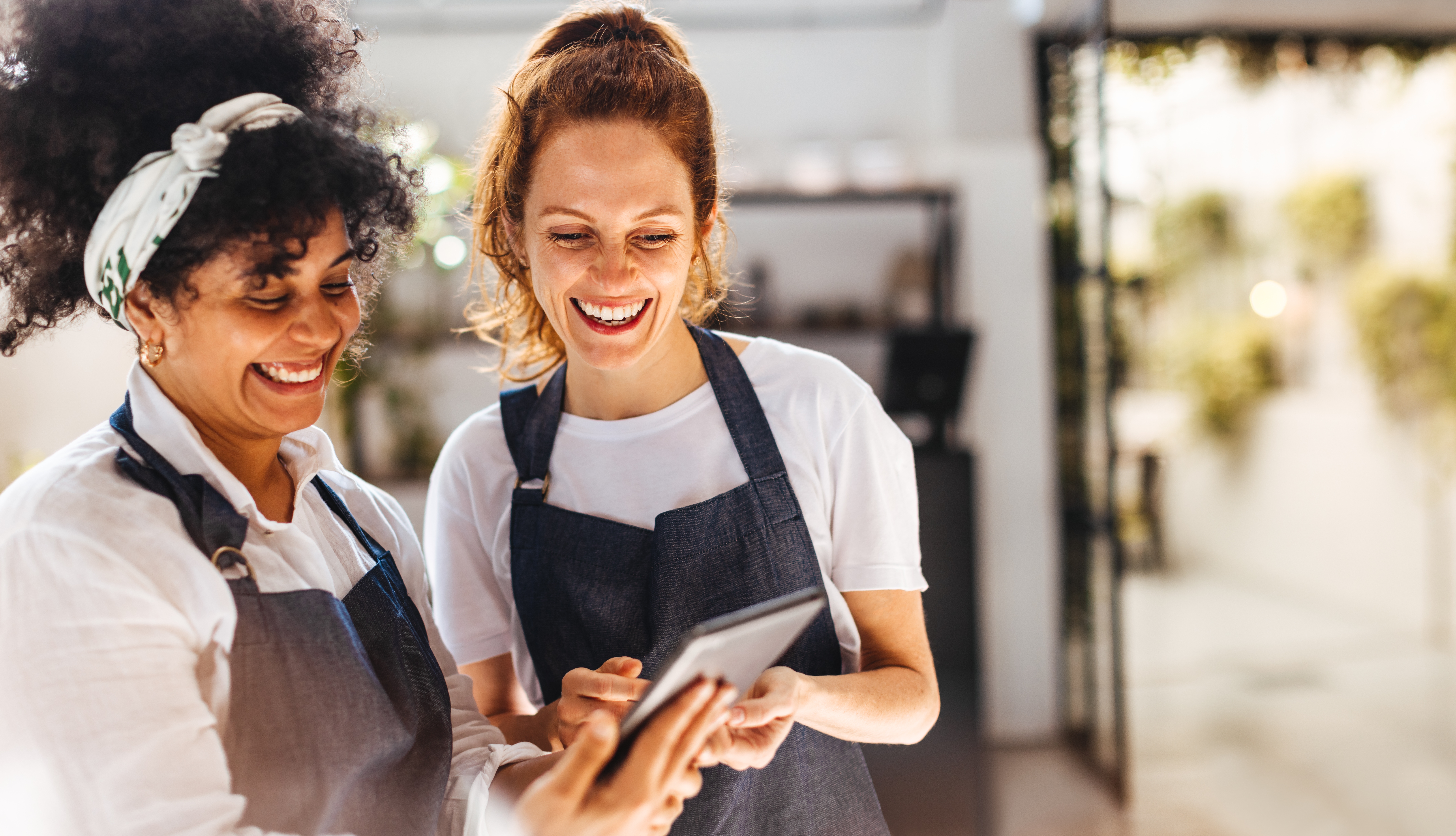 Happy,Female,Employees,Using,A,Mobile,App,On,A,Tablet