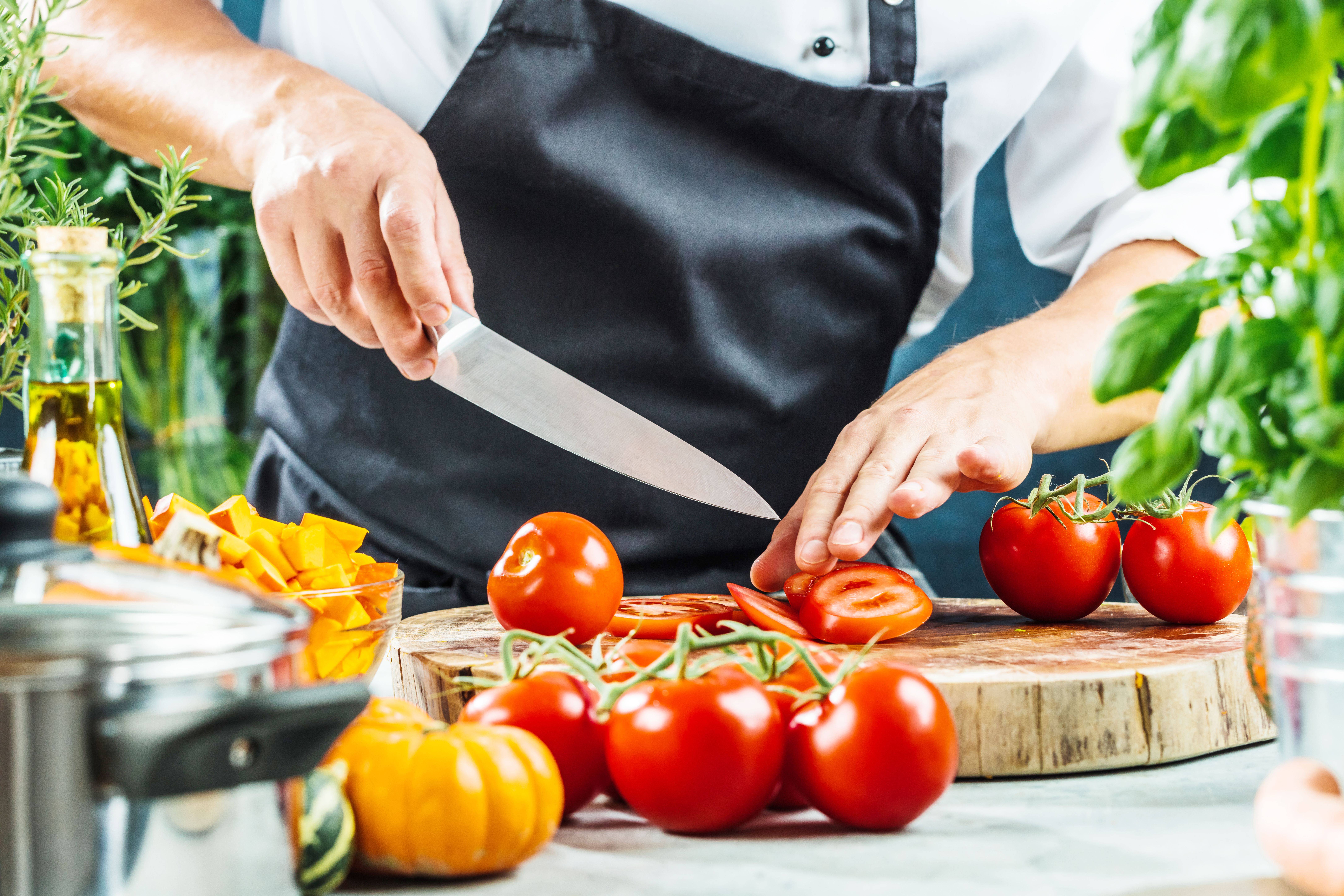Chef,Slicing,Fresh,Ripe,Tomatoes,On,A,Board